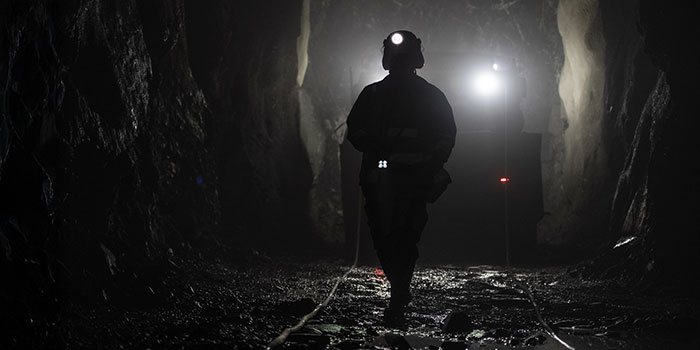 Mörk gruvgång med en siluett av en gruvarbetare