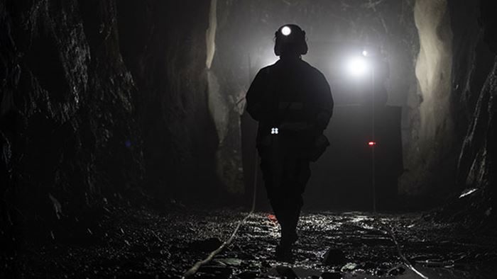 Mörk gruvgång med en siluett av en gruvarbetare