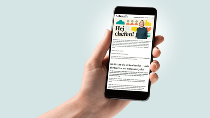 Hand som håller i mobiltelefon där man ser nyhetsbrevet som heter Hej chefen
