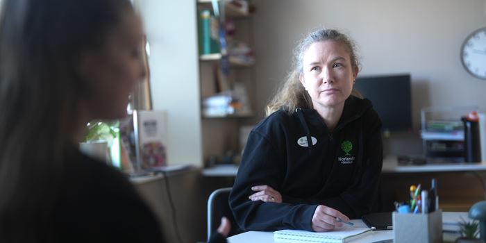 Två personer som samtalr vid ett skrivbord