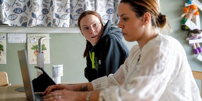 Två personer som samtalar vid ett skrivbord