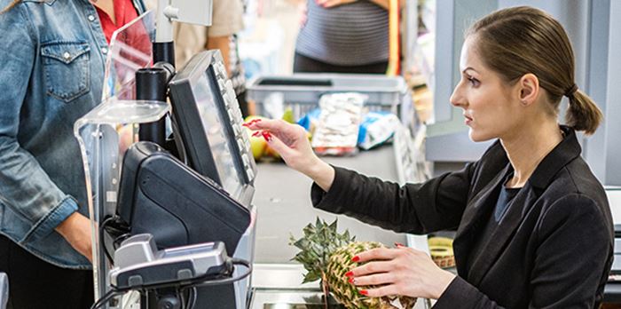Kassörska som slår in numret för en ananas