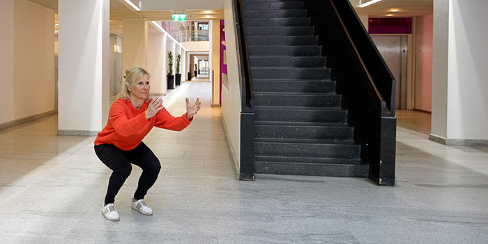 Kvinna gör benböj i ett trapphus