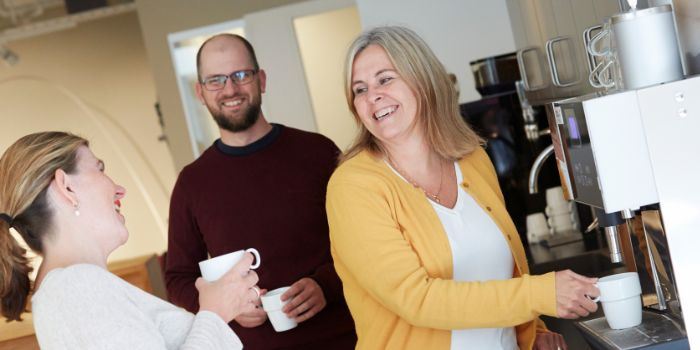 Tre personer vid kaffeautomaten