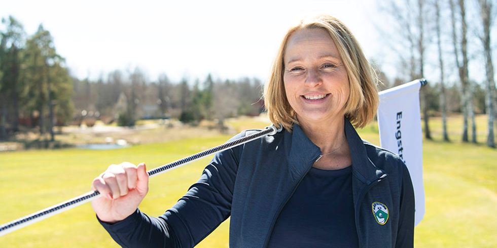 Porträtt av kvinna på golfbana