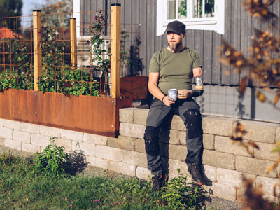 Tonney Forsberg hemma i sin trädgård med en kaffekopp i handen.