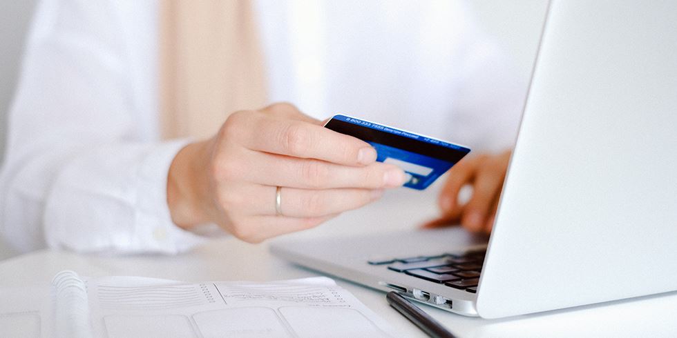 Kvinna betalar ett internetköp med sitt kreditkort
