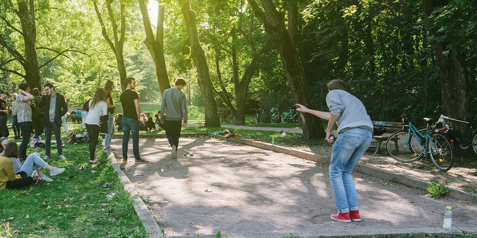 Team som spelar boule tillsammans i kvällsljus. 
