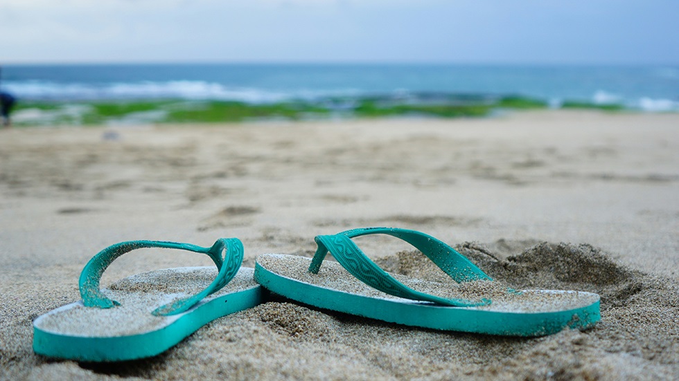 Ett par blå flip-flopsandaler på en strand