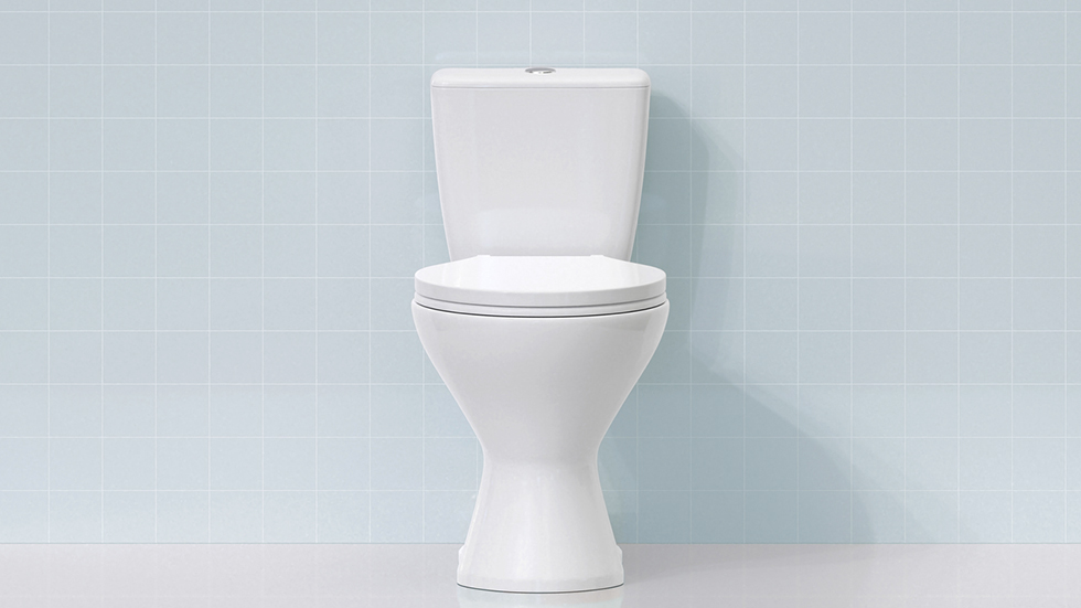 En vit toalett mot ljusblått kakel.