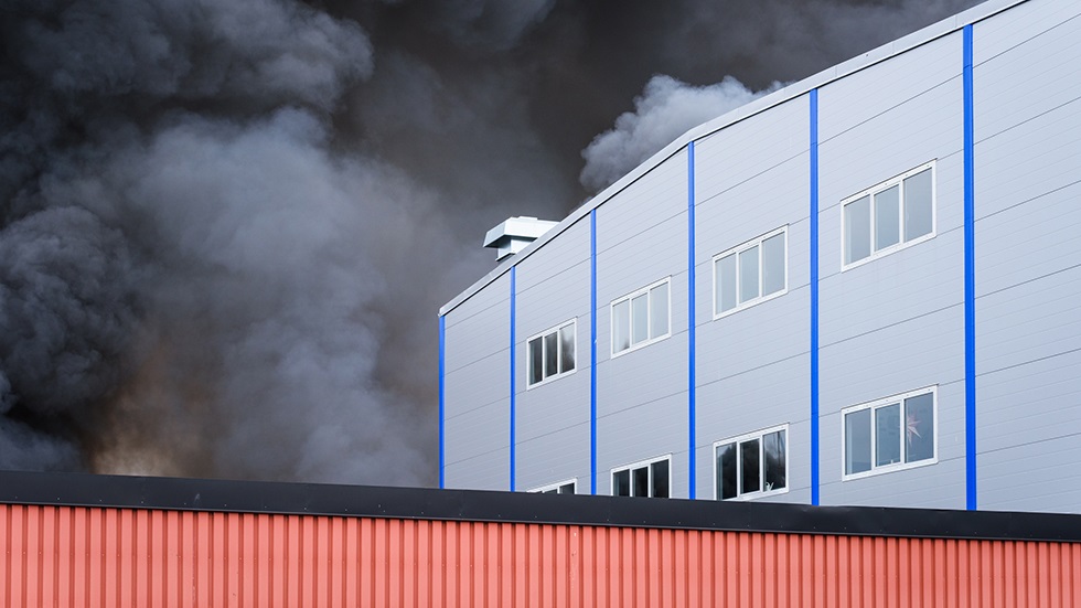 Röd och vit industribyggnad som brinner