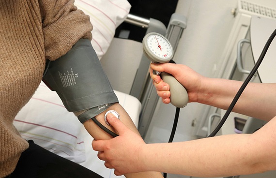 En sjuksköterska mäter blodtrycket på en patient.