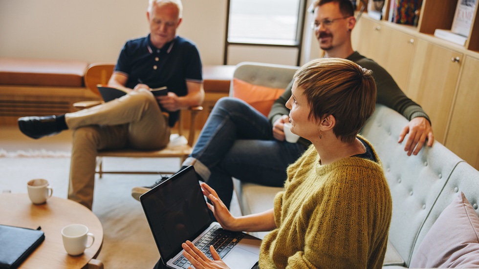 En grupp kollegor sitter runt ett bord och diskuterar.