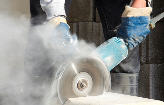 En hantverkare använder ett skärverktyg för att skära i sten.