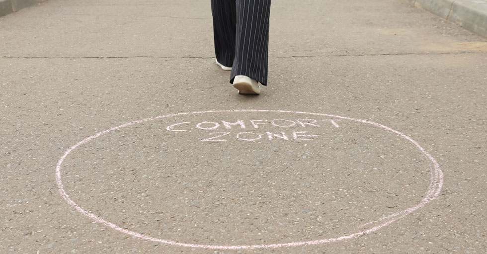 En person har klivit ur en ring på marken där det står "comfort zone".