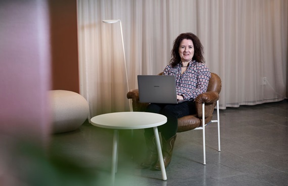 Christina Bodin Danielsson sitter med en laptop i knät i ett avskalat kontor.