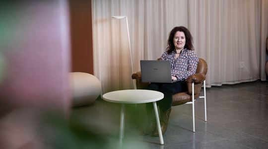 Christina Bodin Danielsson sitter med en laptop i knät i ett avskalat kontor.