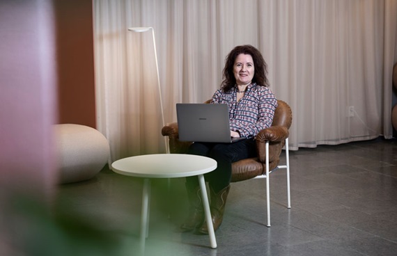 Christina Bodin Danielsson sitter med en laptop i knät i ett avskalat kontor.