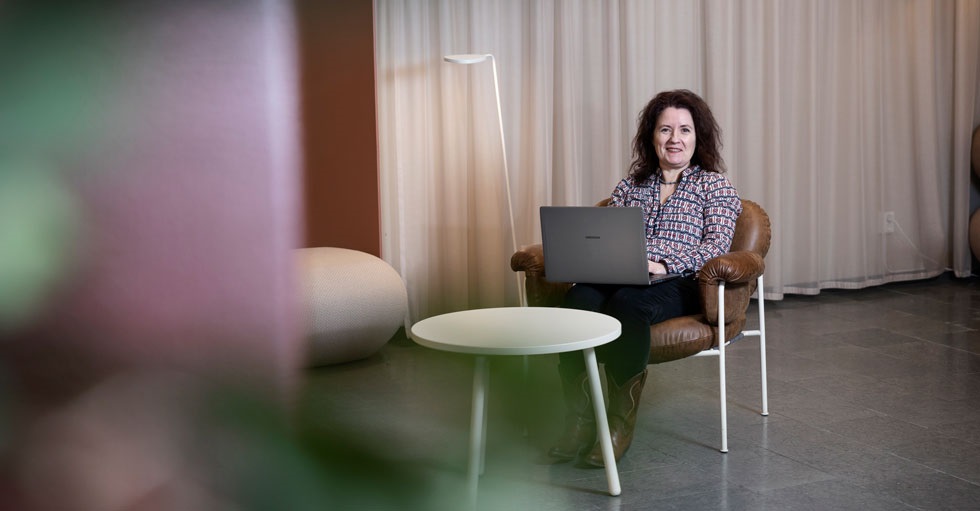 Christina Bodin Danielsson sitter med en laptop i knät i ett avskalat kontor.