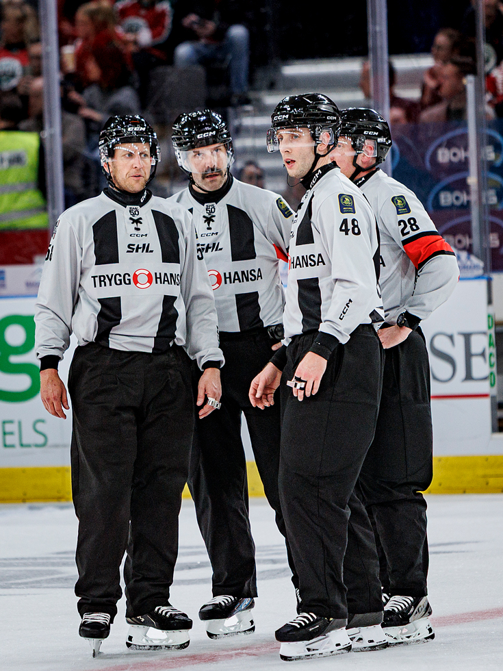 De fyra domarna uppställda ute på isen.