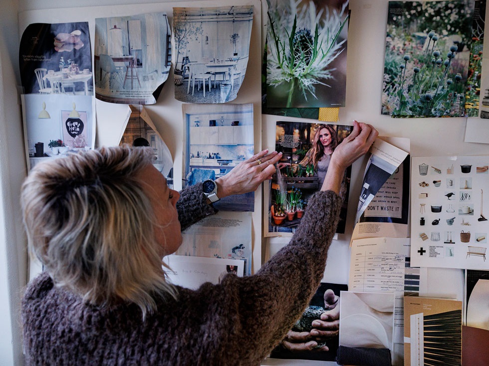 Sara Edhäll, en av ägarna på Iris Hantverk, sätter upp urklipp på en moodboard på väggen.