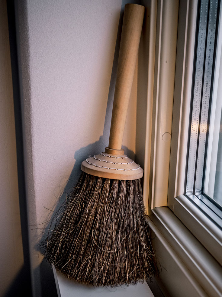 En sopkvast lutad i ett fönster.